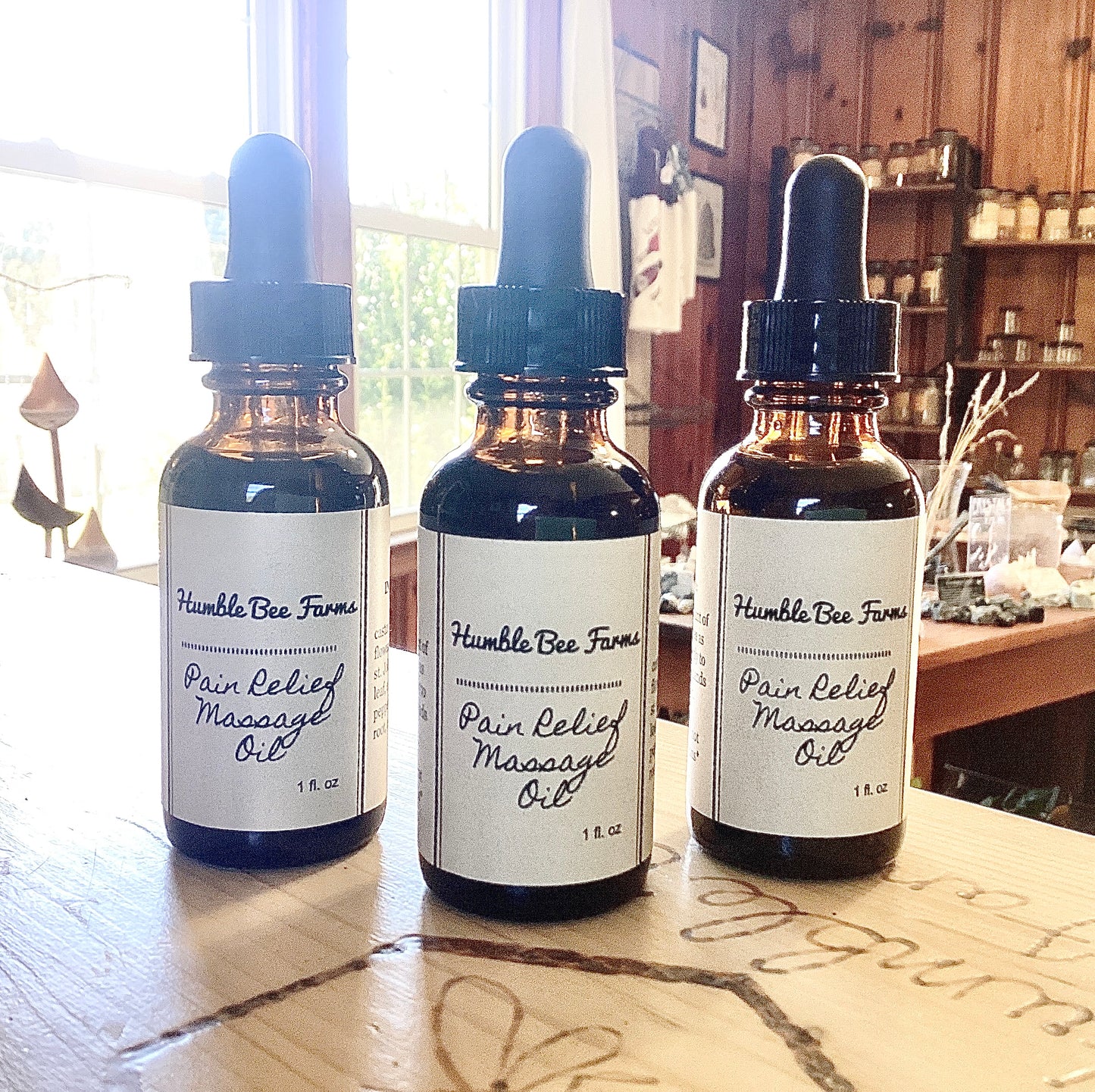 Bottles of Humble Bee Farms Pain Relief Massage Oil. The perfect addition to a healing massage. 